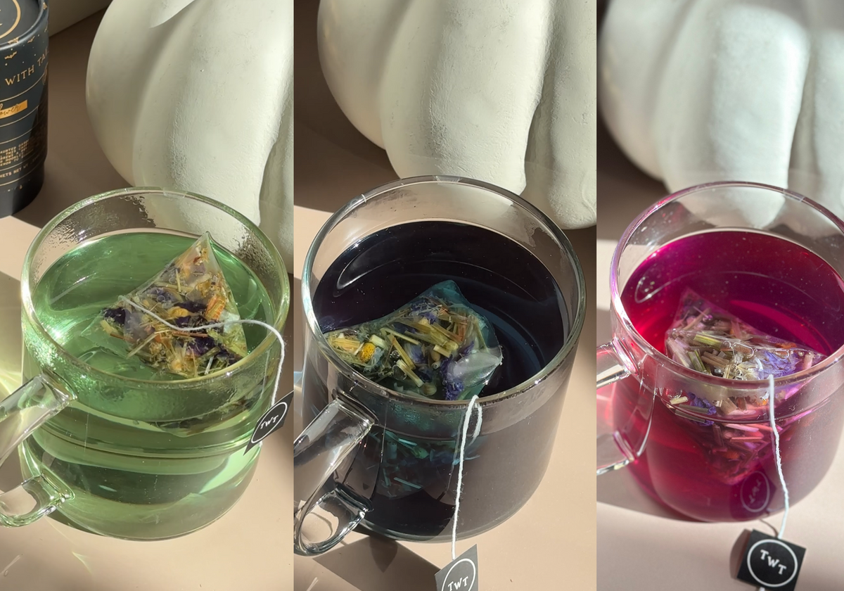 Three glass mugs with Tea With Tae pyramid tea sachets steeping in green, deep blue, and pink colored teas, showing vibrant brewed tea varieties.